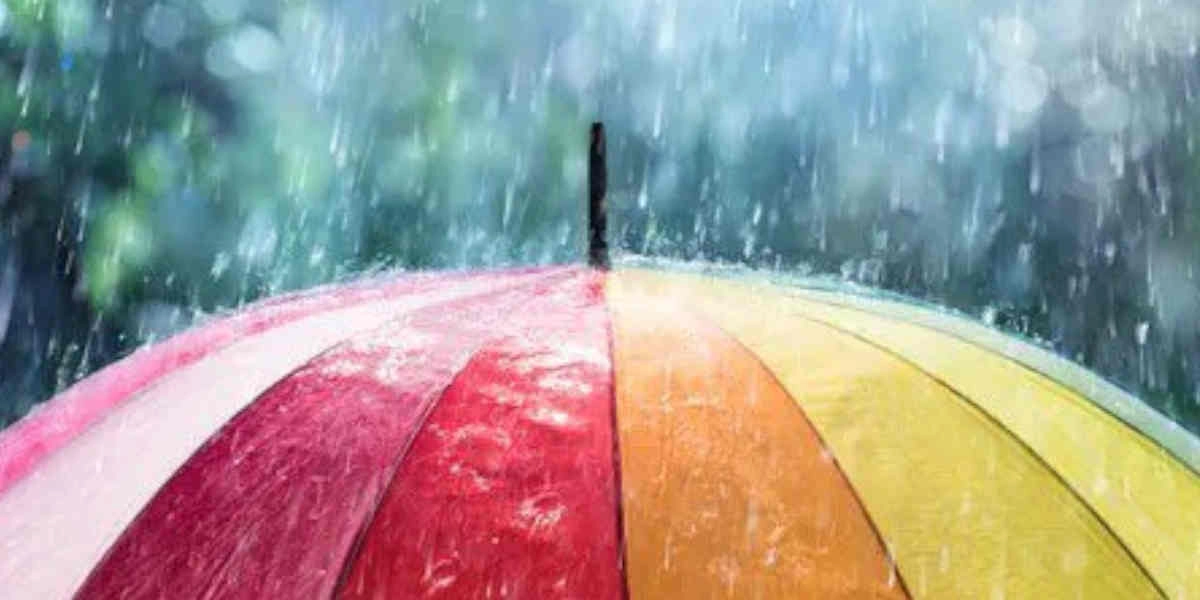 Bunter Regenschirm mit roten, orangefarbenen, gelben und grünen Segmenten im starken Regen, symbolisiert Wetterschutz und Langlebigkeit