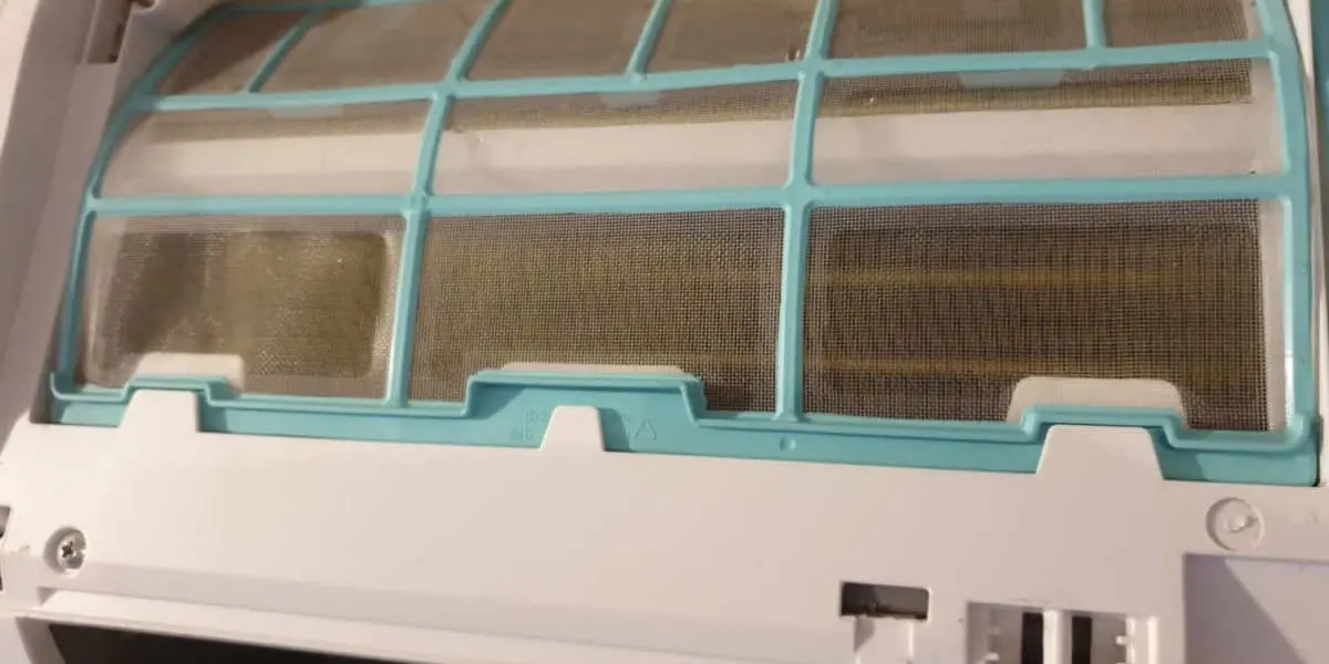 Nahaufnahme eines schmutzigen Klimaanlagenfilters, der mit Staub bedeckt ist und die Notwendigkeit regelmäßiger HVAC-Wartung und Reinigung hervorhebt