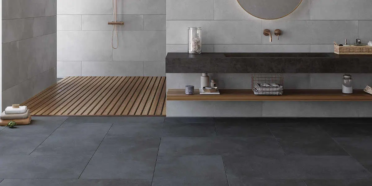 Baño moderno con pisos oscuros, piso de ducha de madera listonada, mueble flotante y espejo redondo