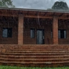 Heavy rain on a tiled roof in Paraguay with an overflowing gutter and wet house facade